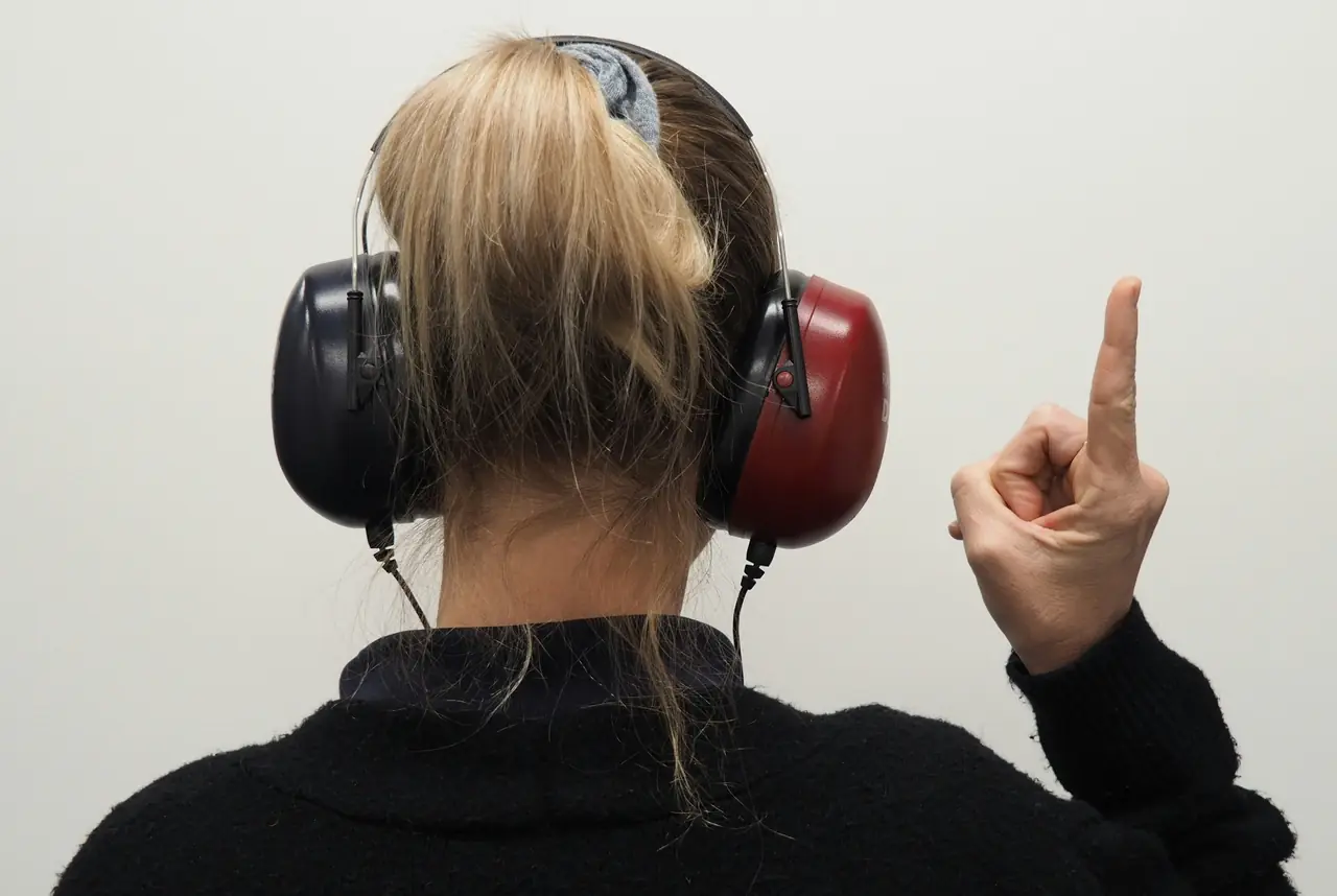 An audiologist examining a patient's ear with a handheld otoscope before a hearing test