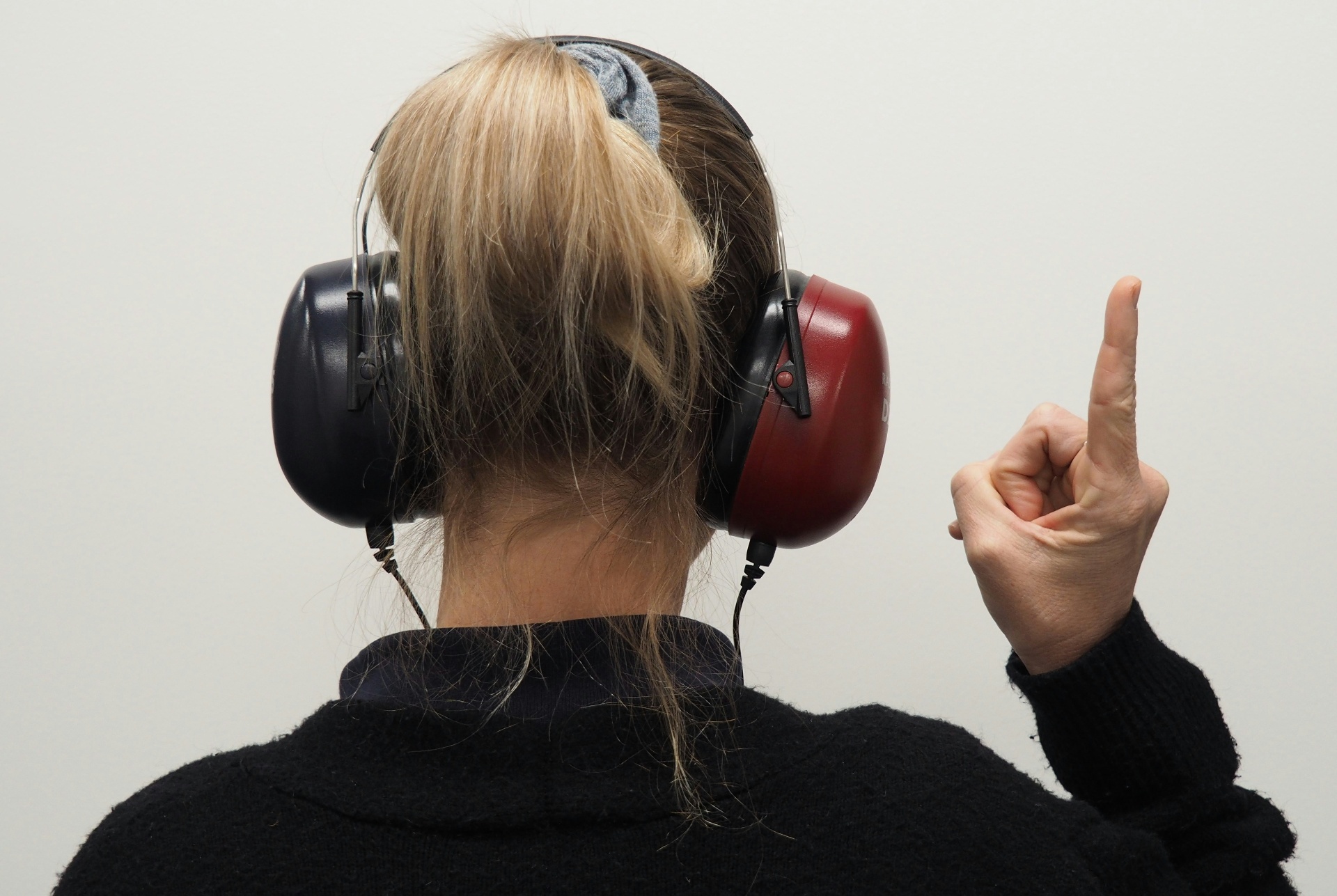 An audiologist examining a patient's ear with a handheld otoscope before a hearing test