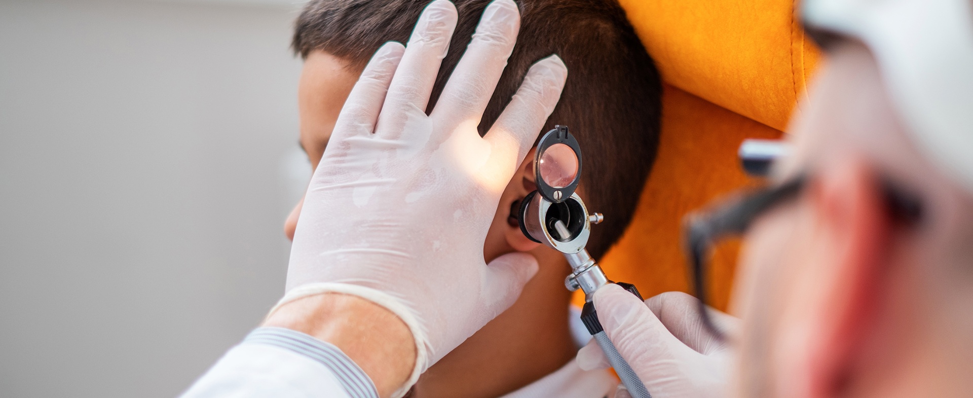 An audiologist gently examining a child's ear with an otoscope at our Whitchurch, Cardiff clinic